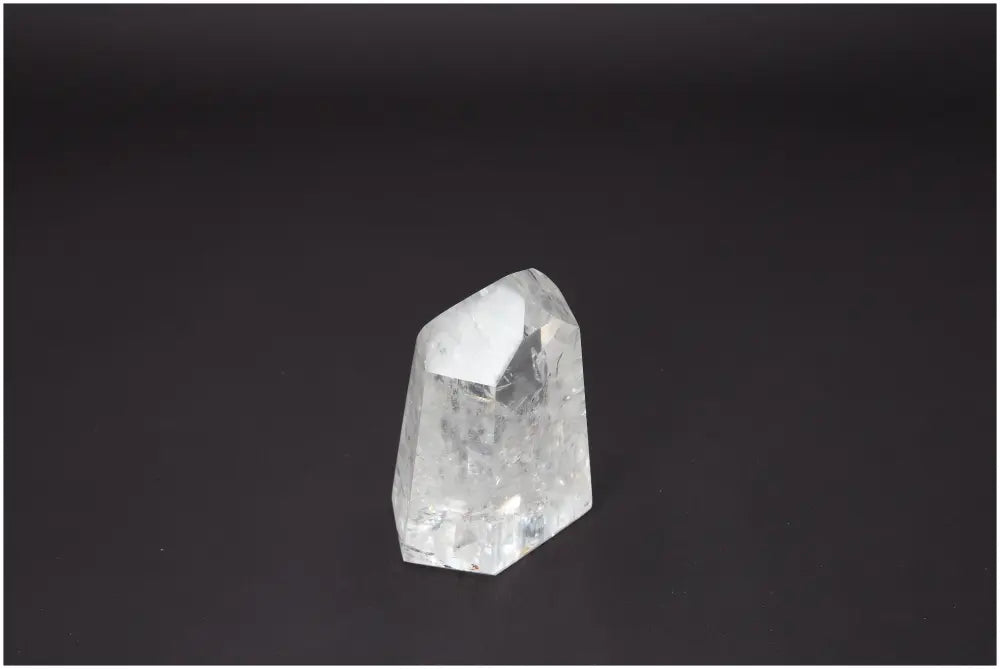 Lemurian Quartz Obelisk on dark background, showcasing clear crystal structure for chakra healing and spiritual energy alignment.