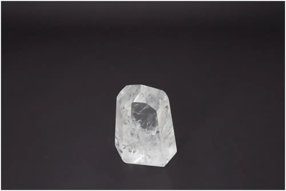 Lemurian Quartz Obelisk on dark background, known for its unique properties affecting body and soul, associated with various chakras.