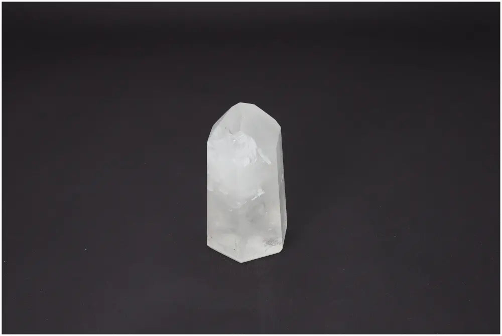Lemurian Quartz Obelisk on dark background, known for its spiritual properties and chakra alignment, enhancing body and soul energy.