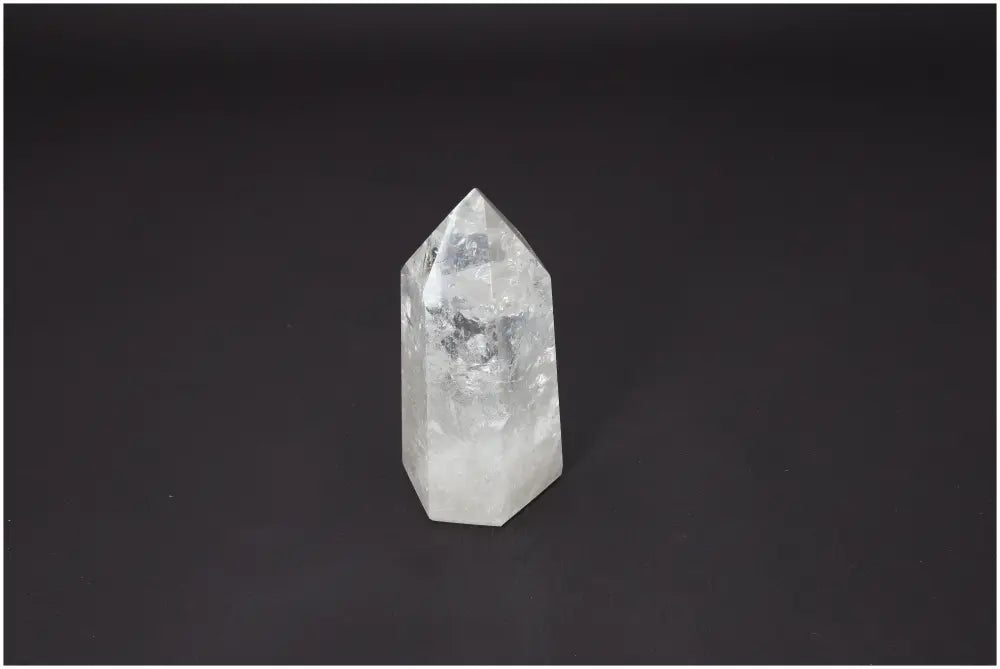 Lemurian Quartz Obelisk on dark background, showcasing its clarity and spiritual energy properties, ideal for chakra healing and meditation.