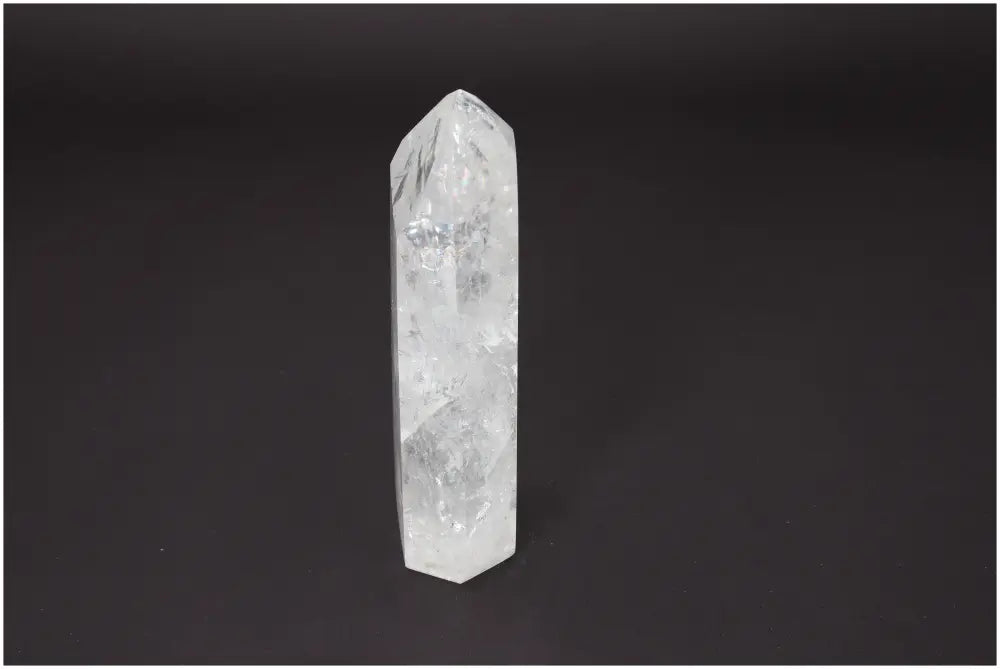 Lemurian Quartz Obelisk against dark background showcasing its clarity and spiritual energy properties.