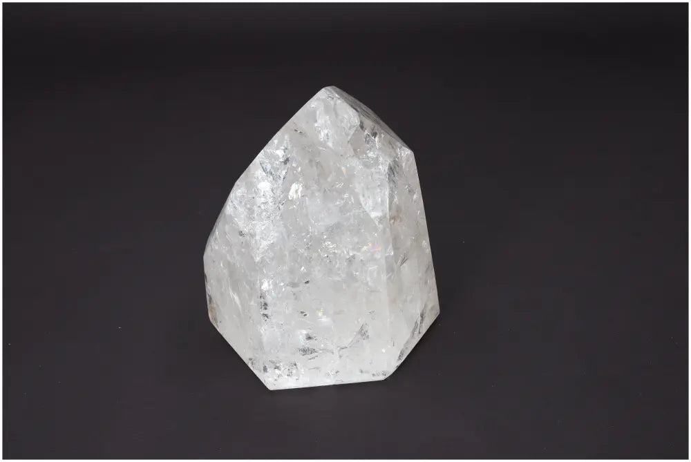 Lemurian Quartz Obelisk on black background showcasing its natural facets and clarity for chakra and spiritual healing.