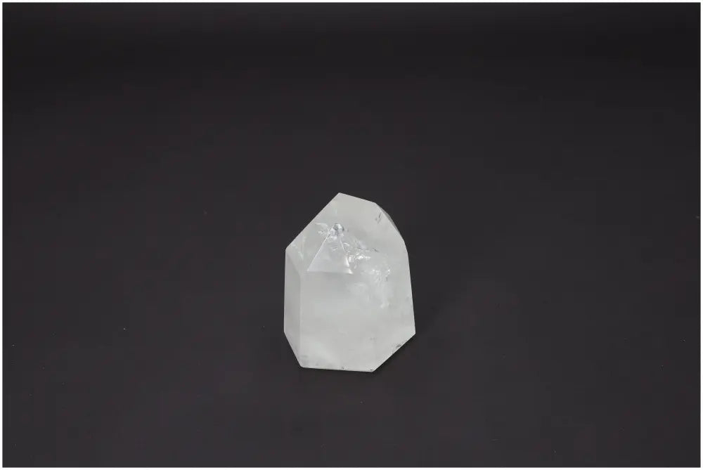 Lemurian Quartz Obelisk against a dark background, clear crystal with unique energetic properties, supports chakras and zodiac signs.