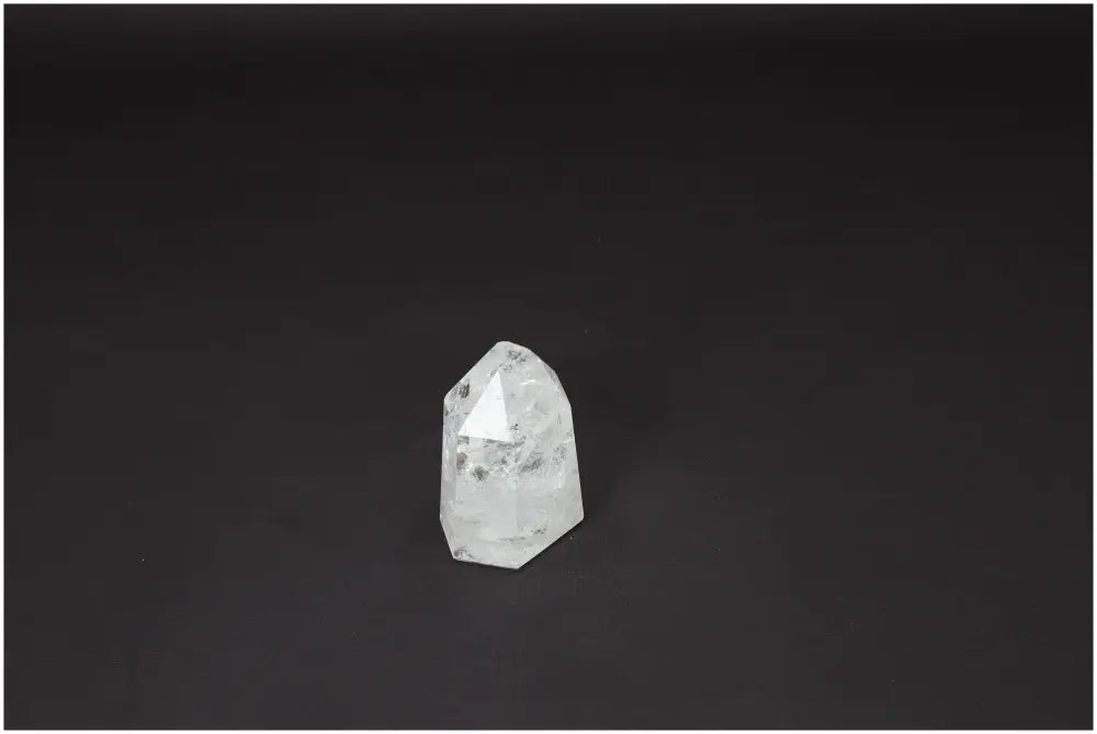 Lemurian Quartz Obelisk on dark background, showcasing its clear crystal properties for chakra and energetic alignment.