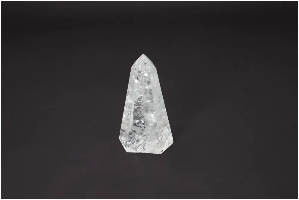 Lemurian Quartz Obelisk against black background, promoting energy and spiritual balance through chakra alignment.