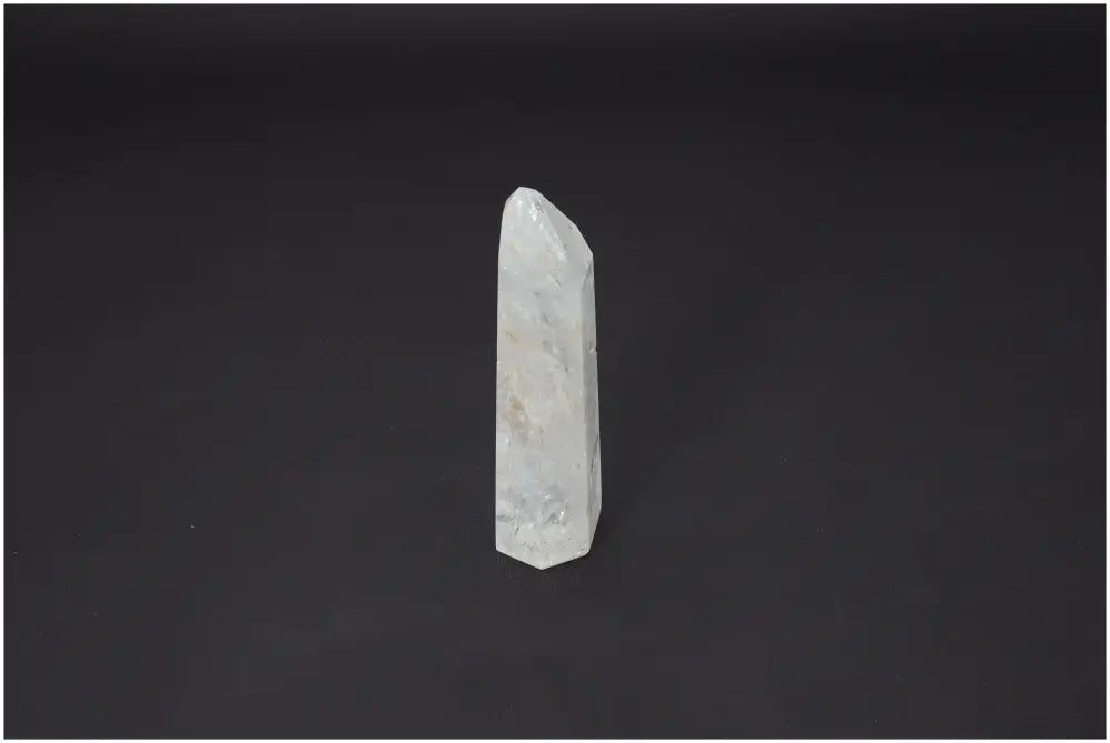 Lemurian Quartz Obelisk on black background, showcasing its natural clarity and connection to chakras and zodiac for spiritual energy.