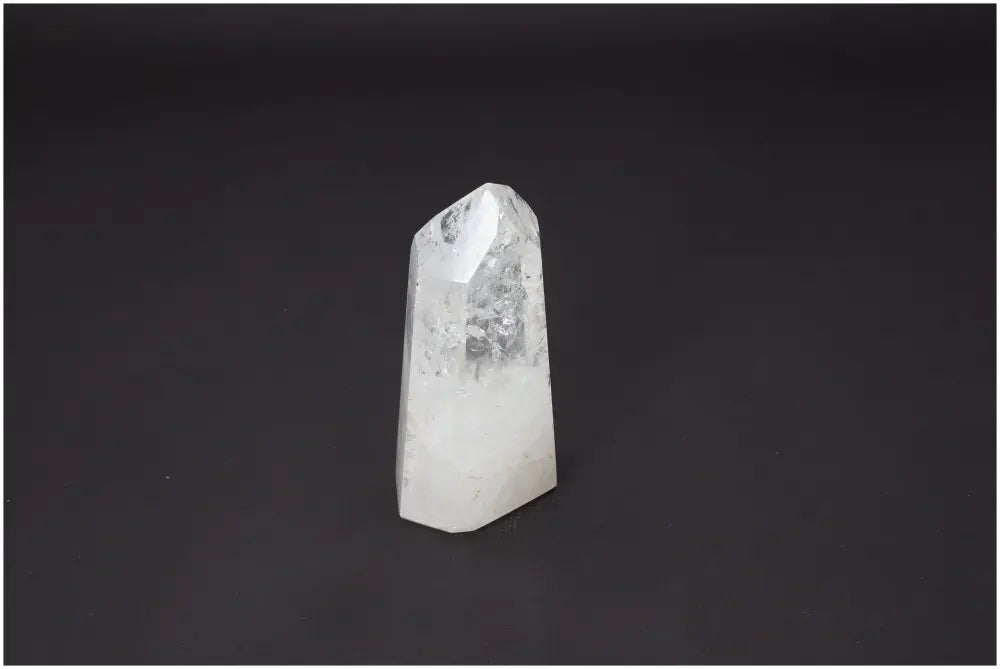 Lemurian Quartz Obelisk on black background, offers unique properties linked to chakras and zodiac, enhancing spiritual energy.