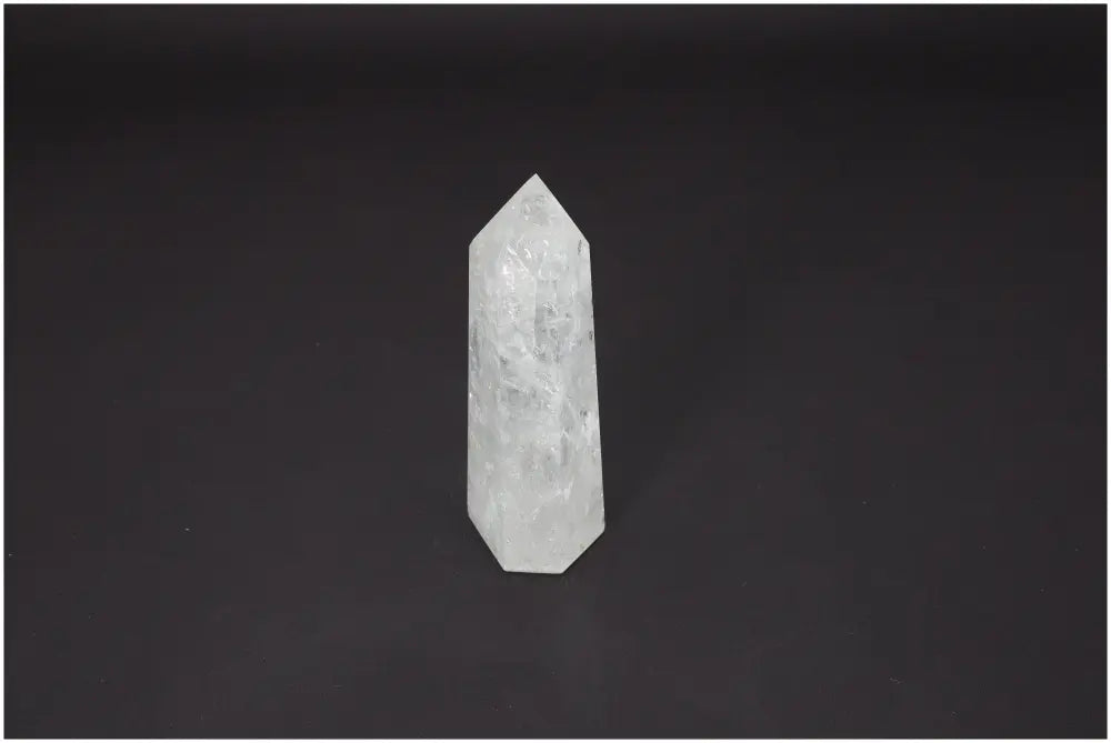 Lemurian Quartz Obelisk crystal for chakra healing and spiritual energy balancing on a dark background.