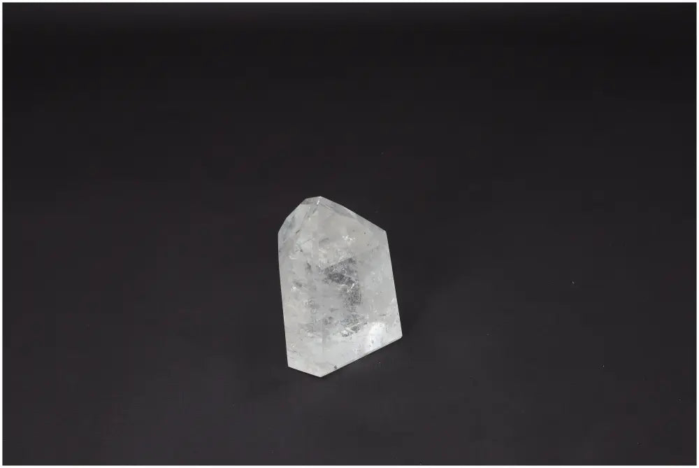Lemurian Quartz Obelisk against dark background, showcasing clear crystal structure and metaphysical properties.