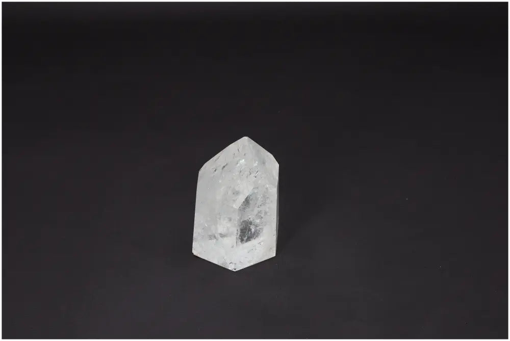 Clear Lemurian Quartz Obelisk against dark background, highlighting its unique energetic properties and natural beauty.