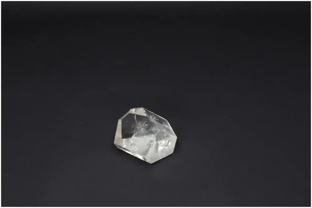 Crystal quartz obelisk against a dark background, showcasing facets and clarity for energetic and spiritual support.