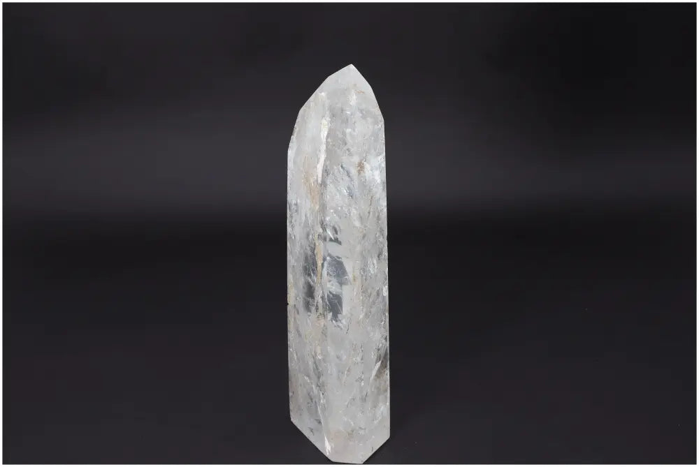 Lemurian Quartz Obelisk crystal elegantly displayed against a dark background, showcasing its natural clarity and powerful healing properties.