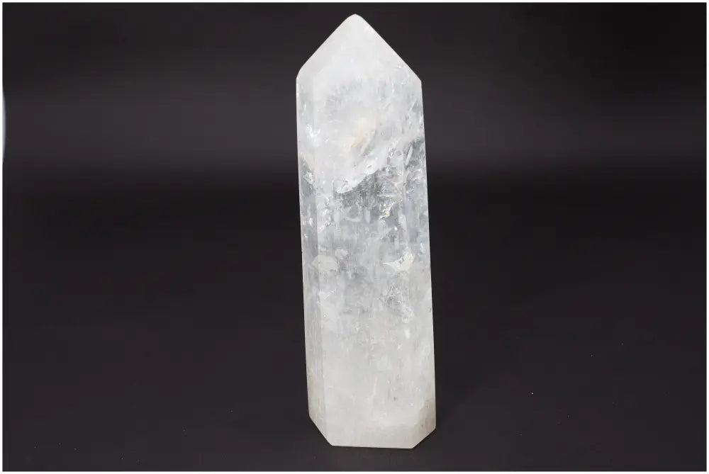 Lemurian Quartz Obelisk crystal against dark background, known for clarity and balance in healing practices.