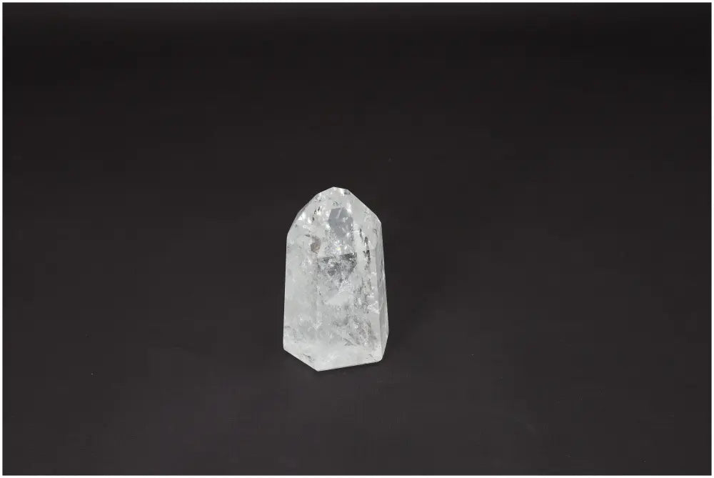 Lemurian Quartz Obelisk crystal on dark background, known for clarity and energy amplification, ethically sourced and naturally formed.