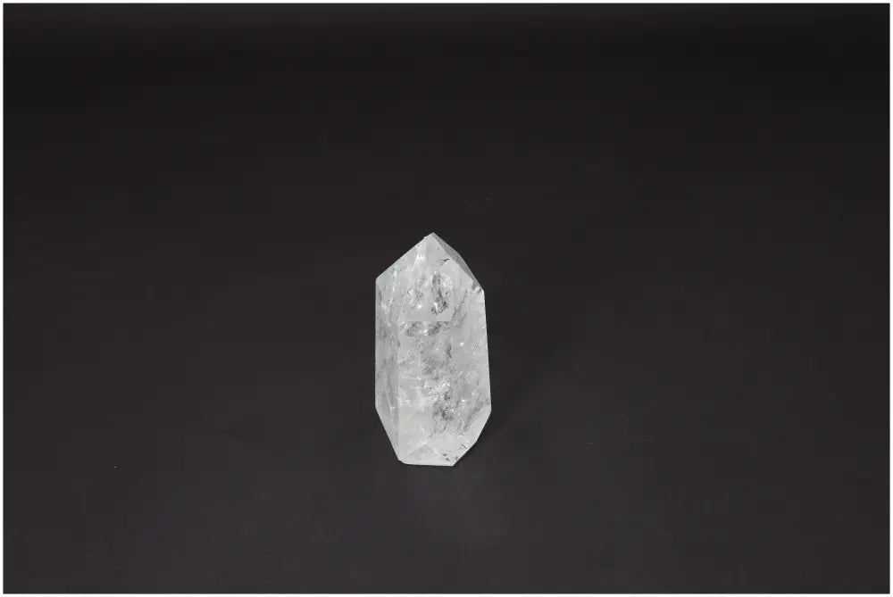 Lemurian Quartz Obelisk crystal on dark background, known for clarity and energy amplification.
