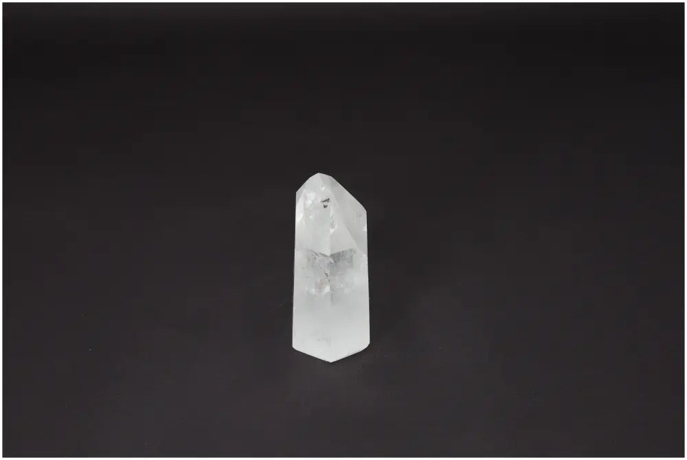 Clear Lemurian Quartz Obelisk on black background, known as Master Healer crystal for clarity, balance, and personal growth.