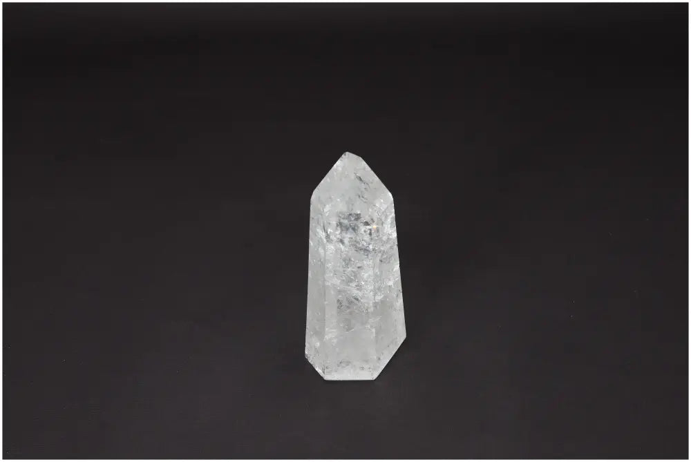 Clear Lemurian Quartz Obelisk against a dark background, known as the Master Healer, enhances clarity and emotional well-being.