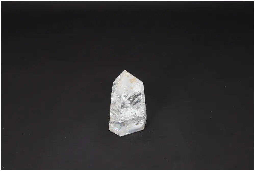 Lemurian Quartz Obelisk on dark background, showcasing its clear, naturally formed crystal structure and spiritual healing properties.