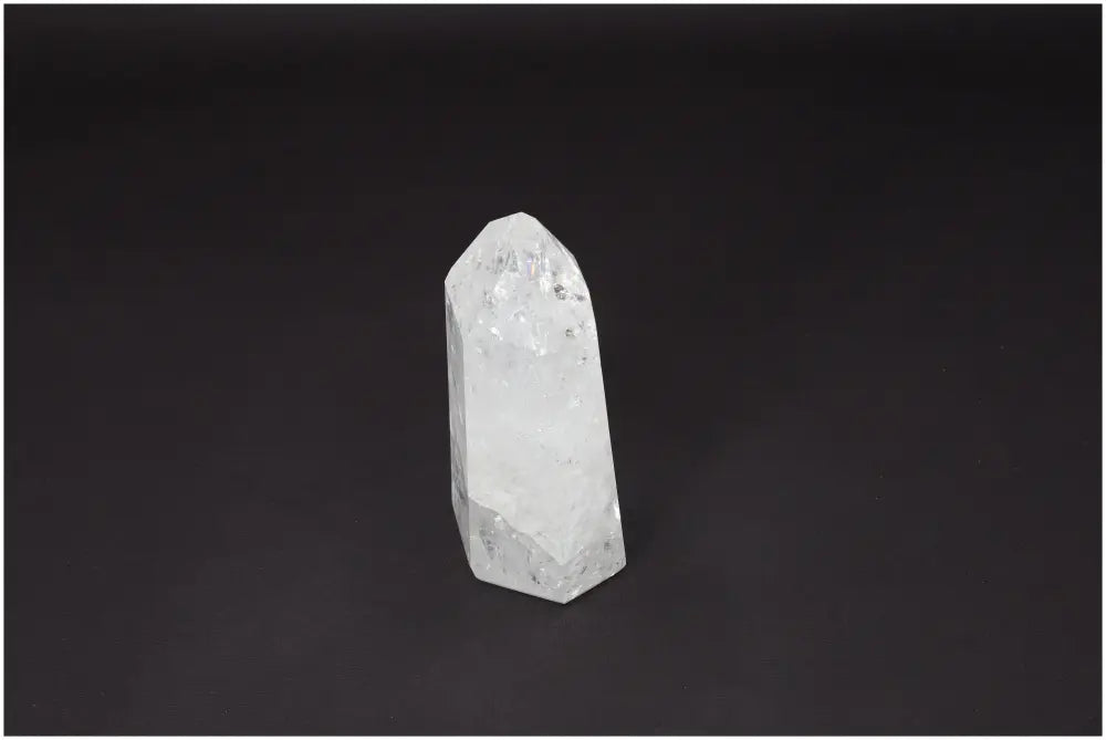 Lemurian Quartz Obelisk clear crystal for energy amplification and healing on a dark background.