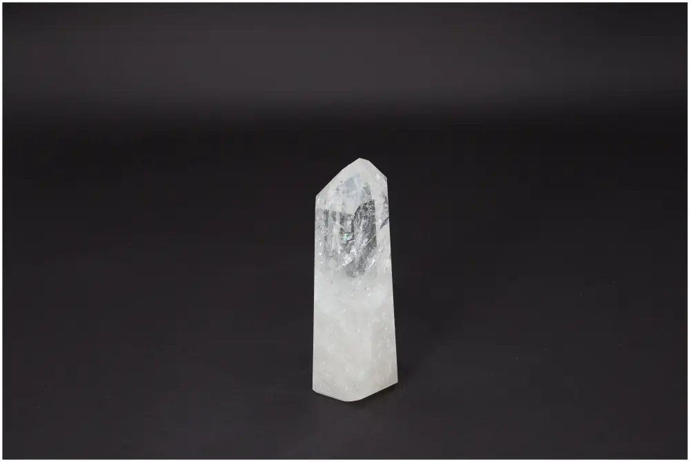 Lemurian Quartz Obelisk on black background, a clear crystal promoting clarity and balance, known as the "Master Healer."