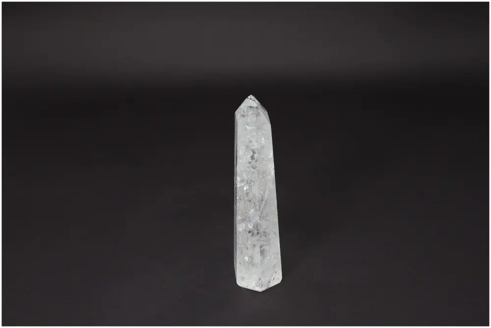 Lemurian Quartz Obelisk crystal on a dark background, known for clarity and balance, amplifies energy and intentions.