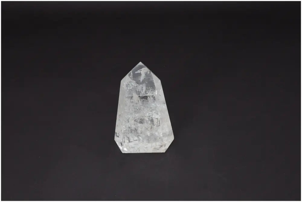 Lemurian Quartz Obelisk crystal on dark background, known for clarity and balance, ethically sourced and naturally formed.