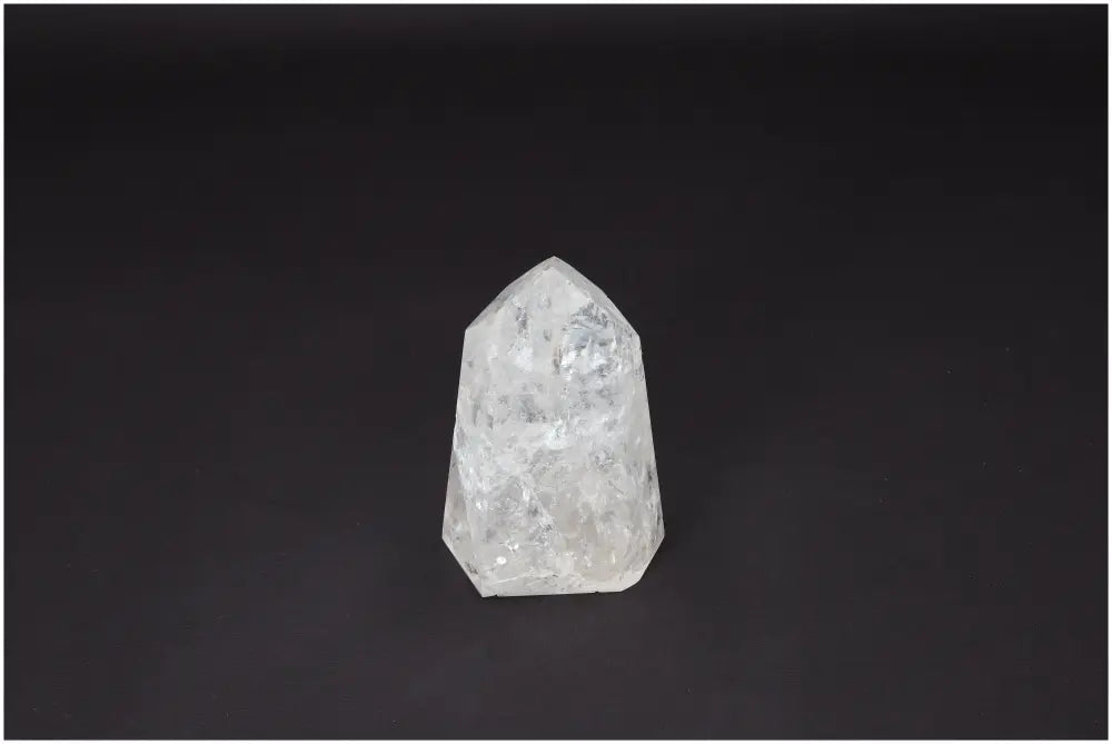 Lemurian Quartz Obelisk crystal against a dark background, known for its clarity-enhancing and energy-amplifying properties.