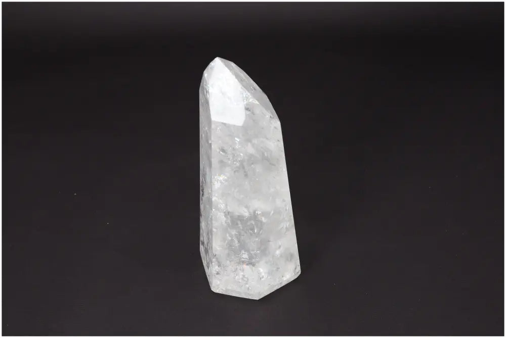 Lemurian Quartz Obelisk on dark background, clear quartz crystal for balance and healing, ethically sourced and naturally formed.
