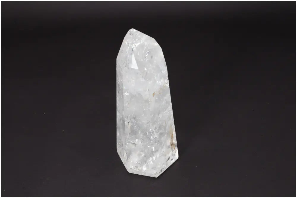 Lemurian Quartz Obelisk against dark background, showcasing clear crystal with natural formation, symbolizing clarity and balance.