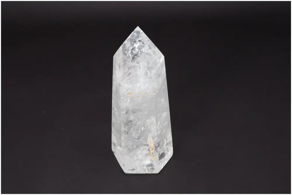 Lemurian Quartz Obelisk crystal standing on a dark background, showcasing its clear, naturally formed facets for clarity and balance.