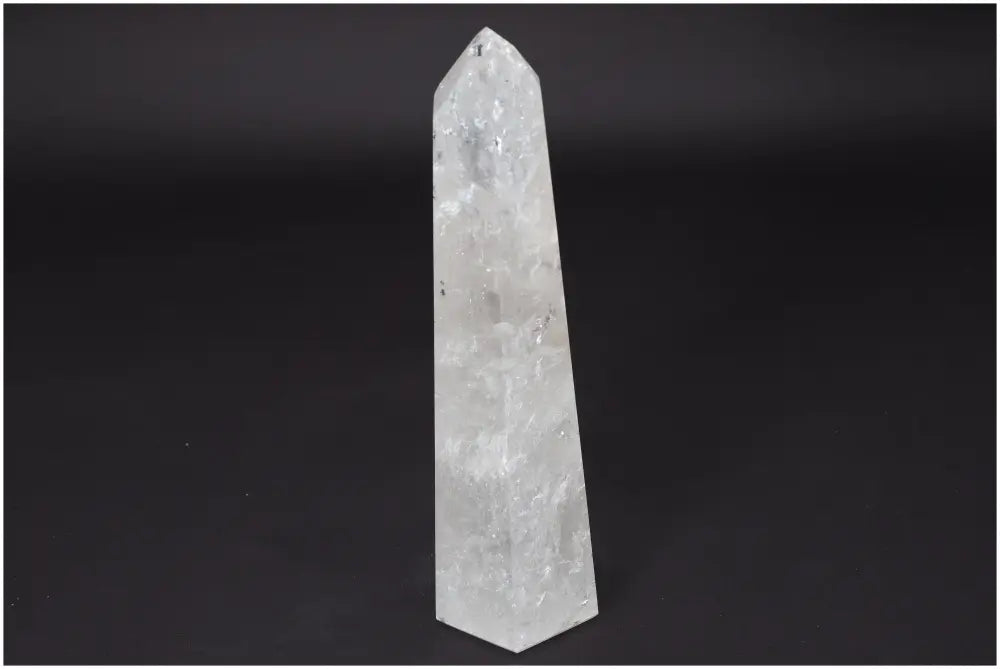 Lemurian Quartz Obelisk, clear quartz crystal, master healer for energy amplification and emotional balance on a dark background.