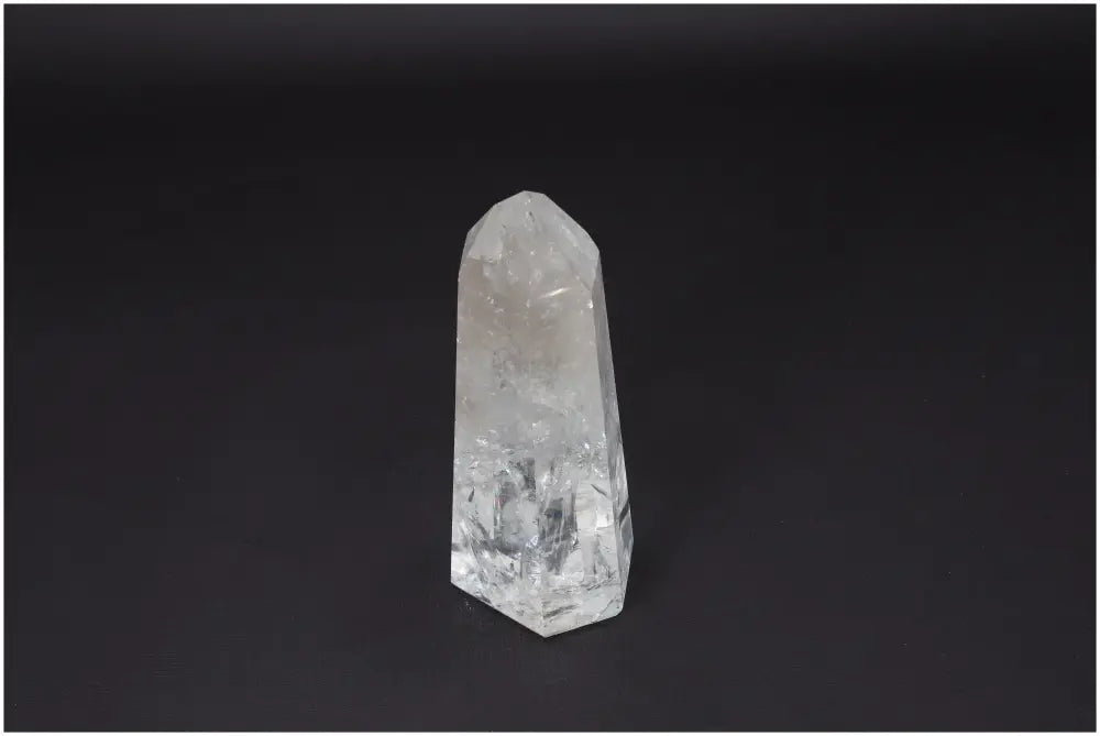 Lemurian Quartz Obelisk on black background, known for clarity, balance, and personal growth; ethically sourced clear quartz crystal.