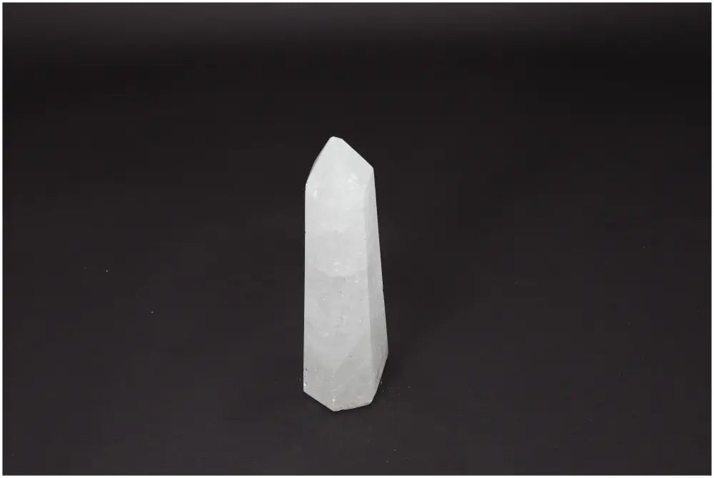 Lemurian Quartz Obelisk on dark background, clear crystal known as the 'Master Healer' for clarity and personal growth.