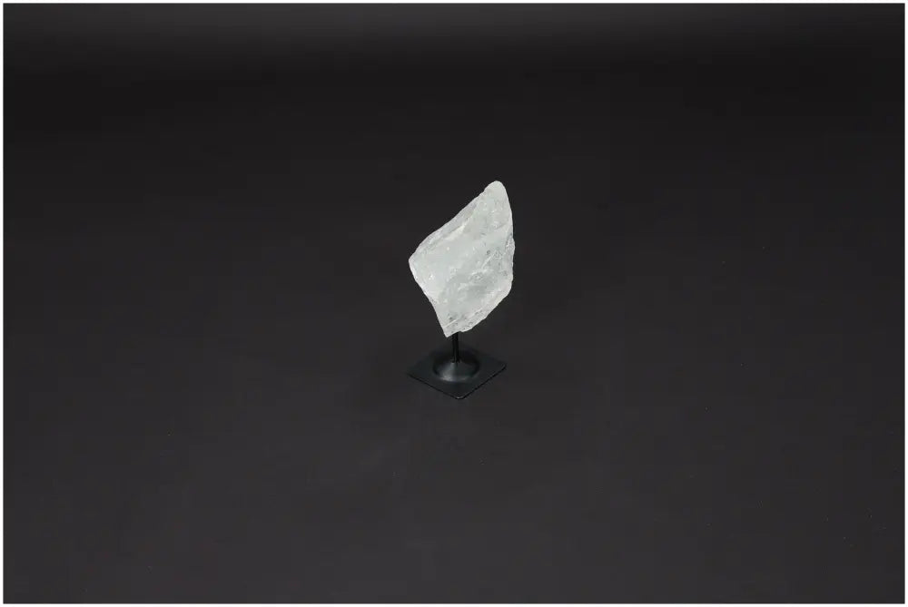 Lemurian Quartz crystal on metal stand, symbolizing clarity, balance, and personal growth, set against a dark background.