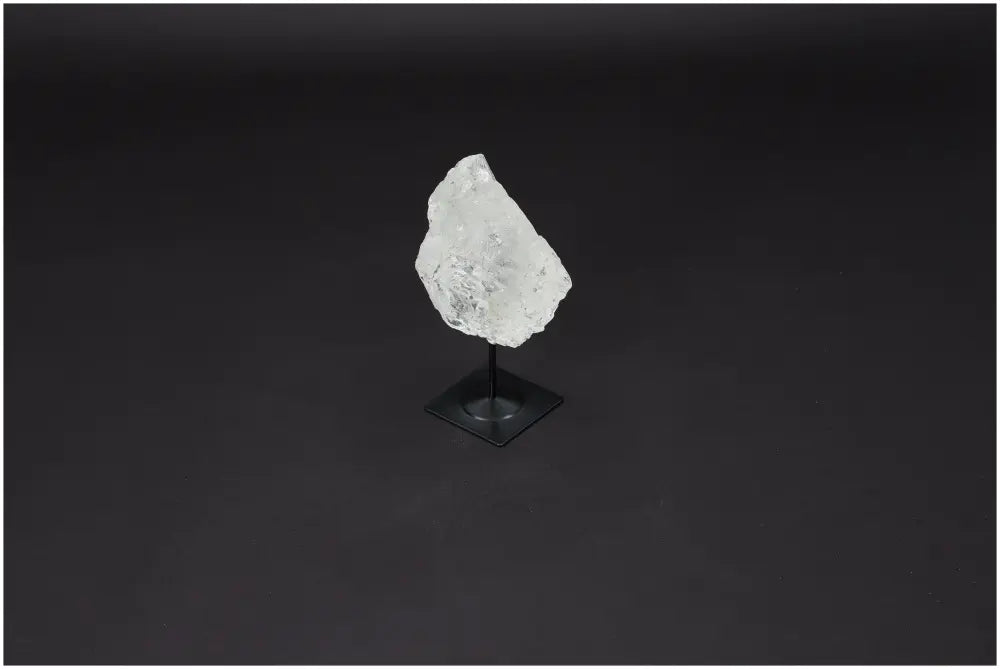 Lemurian Quartz on metal stand against dark background, known for amplifying energy and fostering clarity and personal growth.