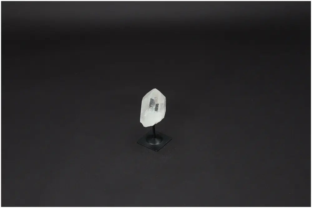 Lemurian Quartz crystal on a metal stand against a dark background, ideal for enhancing clarity and personal growth.