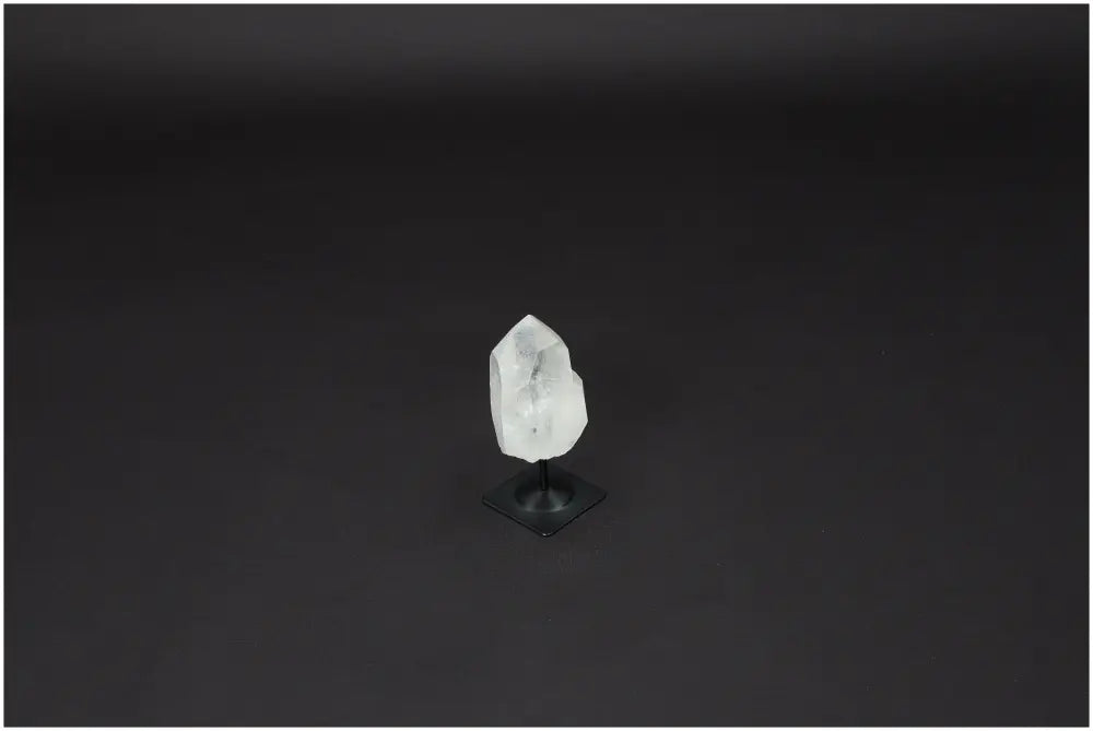 Lemurian Quartz crystal on black metal stand against dark background, symbolizing clarity and personal growth.