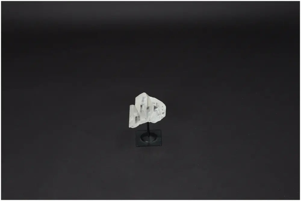 Lemurian Clear Quartz crystal on a black metal stand, symbolizing clarity, balance, and personal growth, known as the Master Healer.