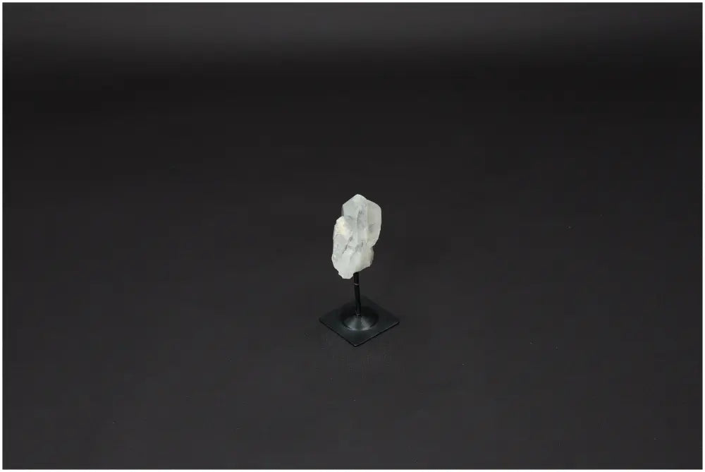 Lemurian Quartz Crystal on a metal stand against a dark background, symbolizing clarity and balance in personal growth.