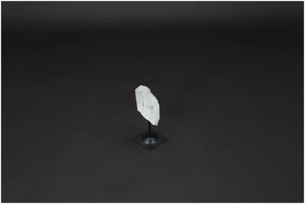 Lemurian Quartz crystal displayed on a sleek metal stand against a dark background, highlighting its natural clarity and pristine formation.