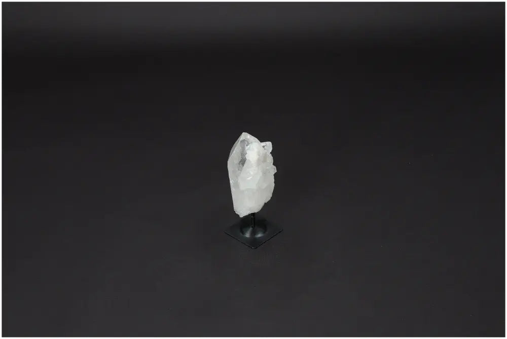 Clear Lemurian Quartz crystal on a metal stand against a black background, ideal for energy amplification and personal growth.