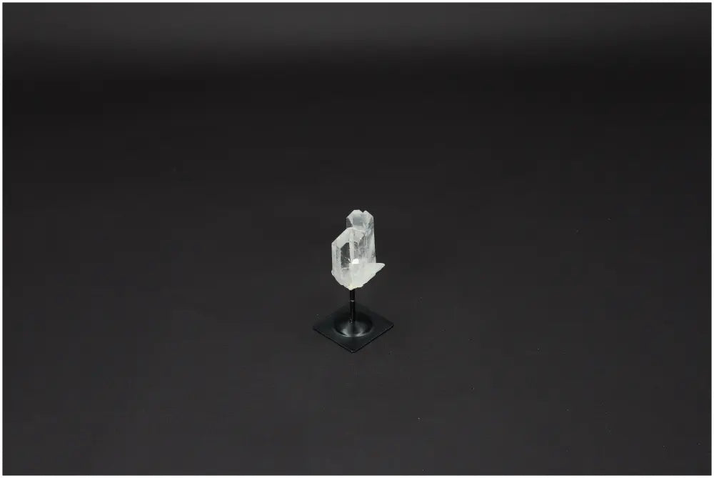 Lemurian Quartz crystal on metal stand against a dark background, exemplifying clarity and balance in crystal healing.