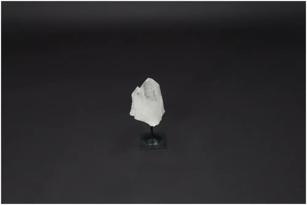 Lemurian Quartz crystal on a metal stand against a dark background, symbolizing clarity and balance.