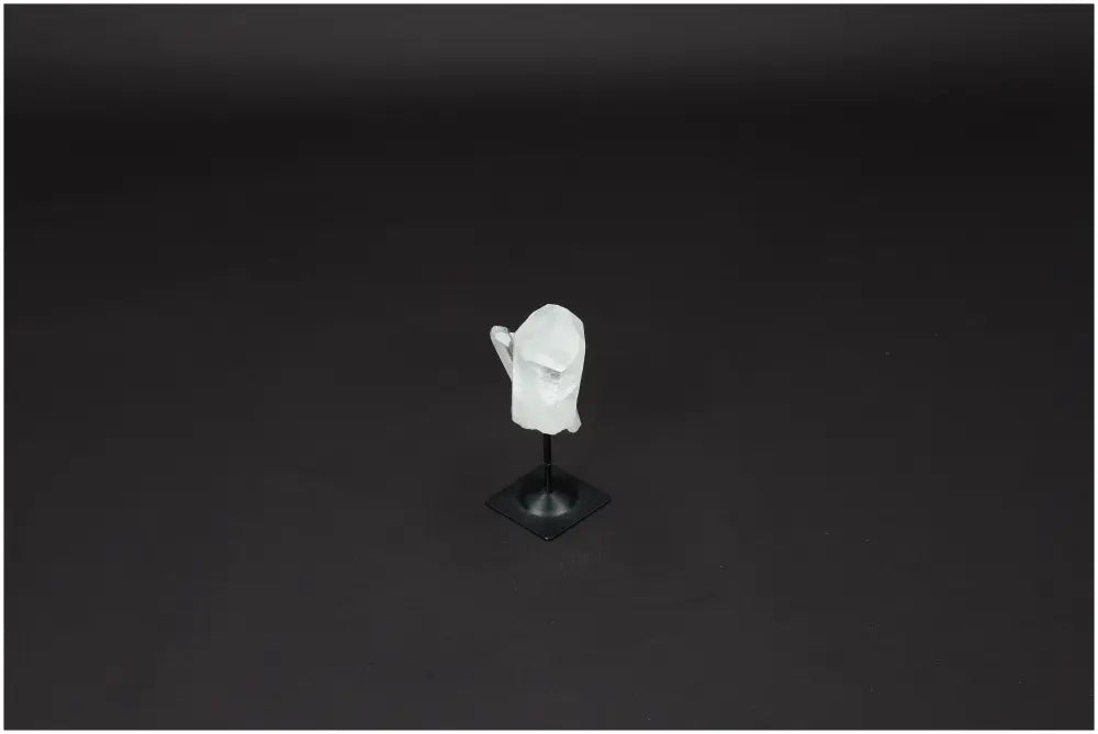 Lemurian Quartz on metal stand against dark background, a crystal known for purification, harmonizing energy, and neutralizing radiation.