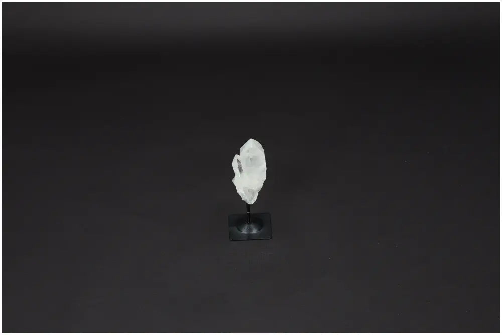 Lemurian Quartz crystal on a metal stand, known for enhancing clarity and balance, displayed against a dark background.