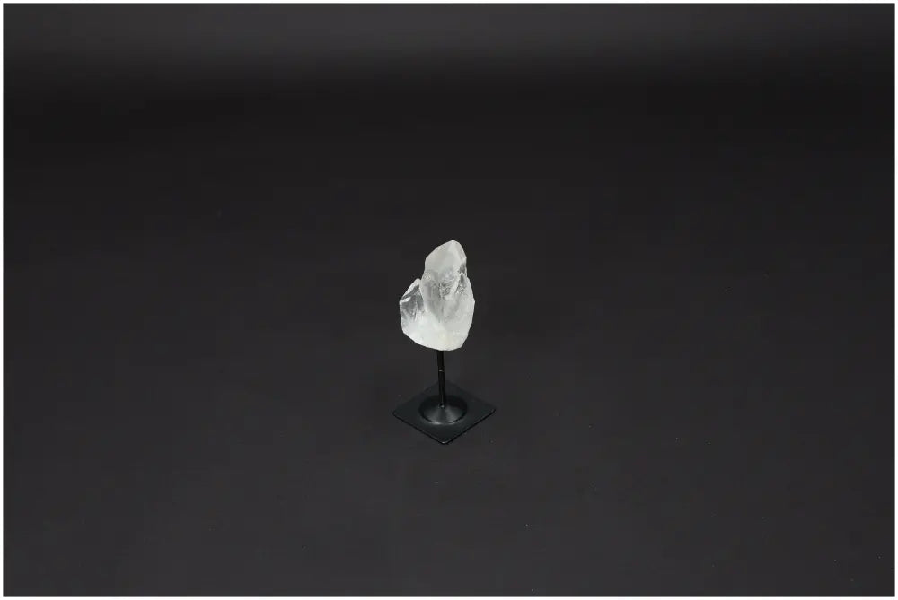 Lemurian Quartz on a metal stand against a dark background, showcasing its clear crystal structure and purifying qualities.