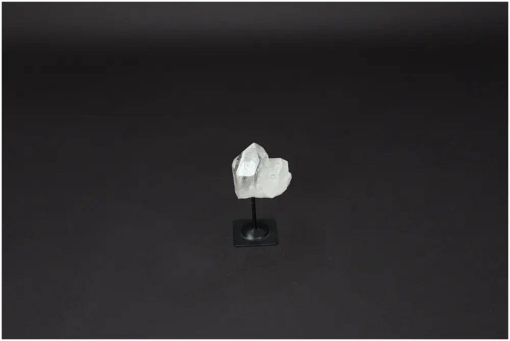Lemurian quartz crystal on metal stand against dark background, ideal for purification and neutralizing negative energy.