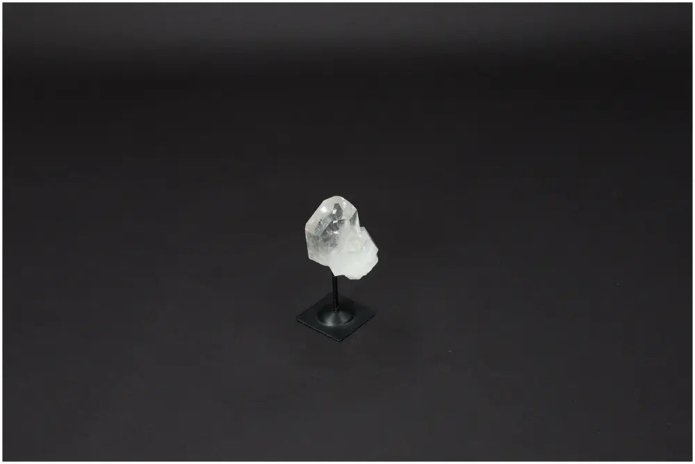 Lemurian Quartz on a metal stand against a black background, showcasing its clarity and purifying energy properties.