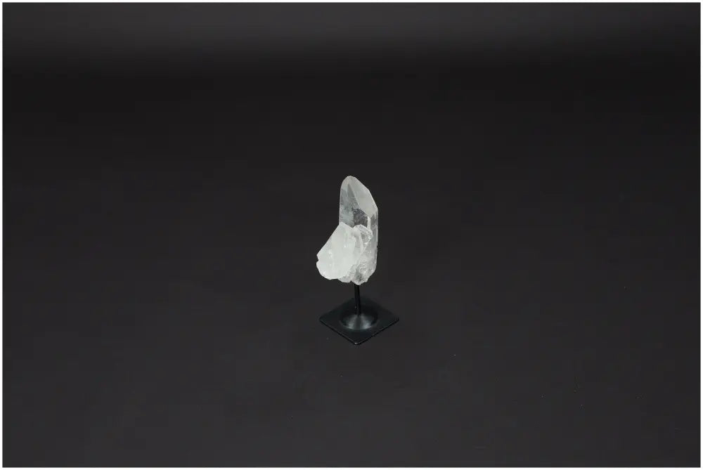 Lemurian Quartz on metal stand against dark background, showcasing its clarity and energy purification properties. Ideal for harmonizing spaces.