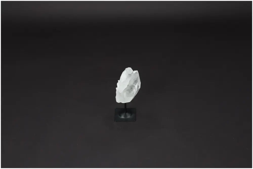 Lemurian Quartz crystal on metal stand, promotes purification and neutralizes negative energy, enhances space with healing vibrations.